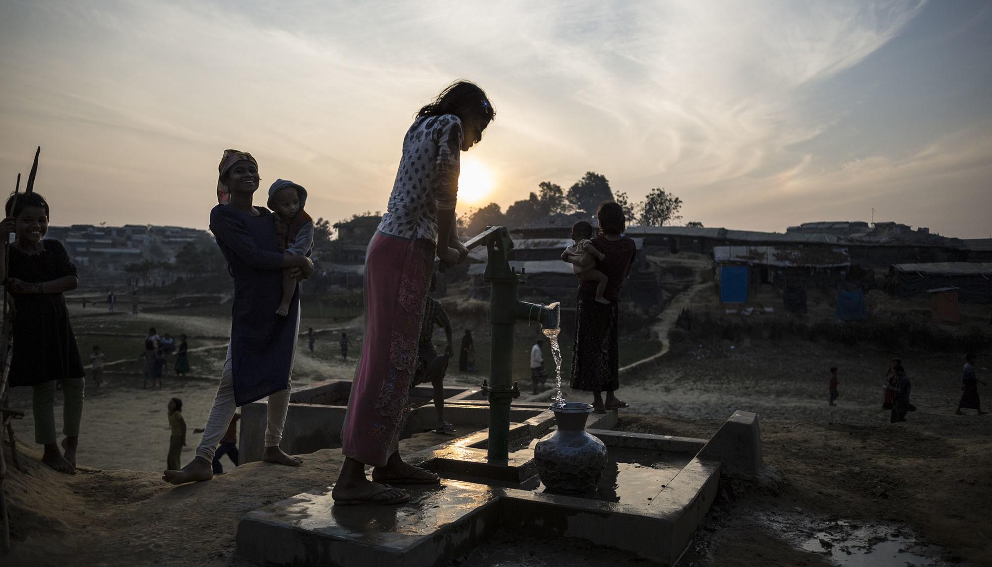 Niña rohingya sacando agua de un pozo.